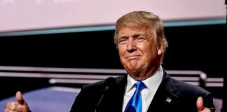 Man in suit giving thumbs up gesture.