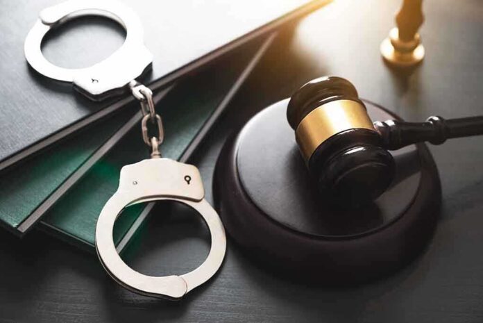 1885320832 featured image Gavel, handcuffs, and books on a table.