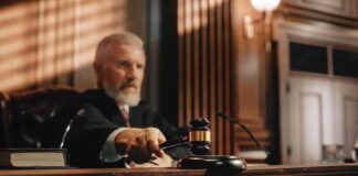 Judge holding gavel in a courtroom setting.