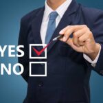 Man in suit selecting yes with pen