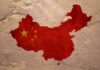 Map of China with flag on textured wall.