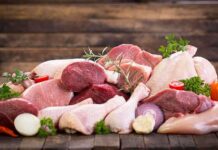 Assorted raw meat with vegetables on wooden table