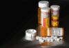 Pill bottles and tablets on a dark surface