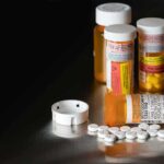 Pill bottles and tablets on a dark surface