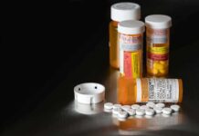 Pill bottles and tablets on a dark surface