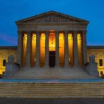 Illuminated courthouse building at dusk with columns
