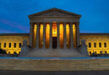 Illuminated courthouse building at dusk with columns