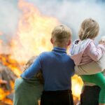 Insurance Meltdown – The Shocking Truth Unveiled Three children and adult watching large fire outdoors