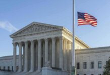 US flag flying outside a neoclassical government building
