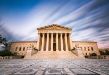 Historic building with columns under a dynamic sky.