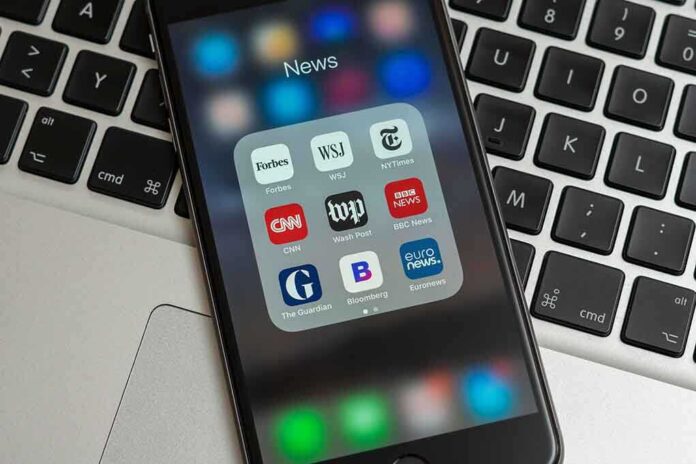 1321128134 featured image Smartphone displaying news app icons on laptop keyboard