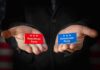 Hands holding Republican and Democratic Party cards