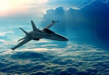Jet flying above clouds in blue sky