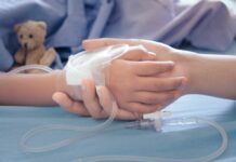 Child hand with IV held by adult