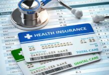 Stethoscope and health insurance cards on medical chart.