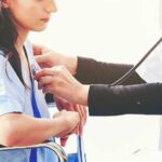 Cancer Cases TRIPLE in Young Adults — Doctors Alarmed Doctor examining patient with stethoscope in hospital