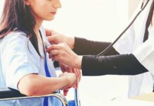 Doctor examining patient with stethoscope in hospital