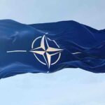 NATO flag waving against blue sky