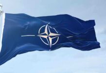 NATO flag waving against blue sky