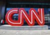 Large red CNN sign outside building entrance