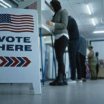 Sign reading Vote Here in a polling station