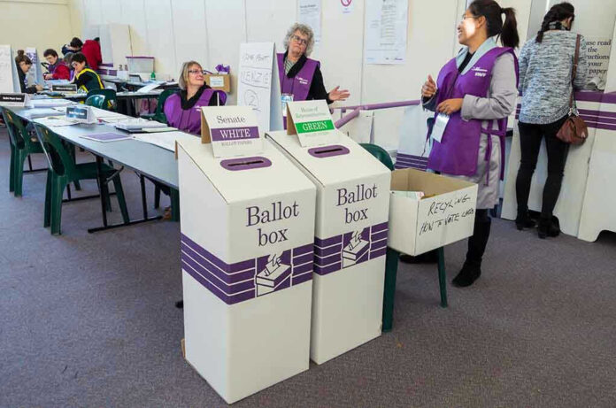 446230945 Election polling station with ballot boxes and officials
