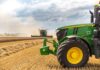 A green tractor in a wheat field