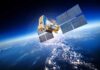 A satellite equipped with solar panels orbiting above the Earth