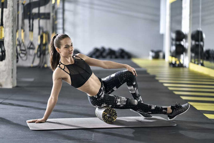 Woman using foam roller in gym setting