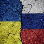 White House Summit: Peace Talks Turn Tidal Cracked Ukrainian and Russian flags painted on concrete
