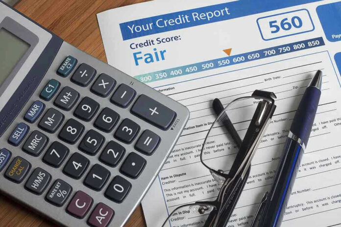 Calculator and glasses on credit report document