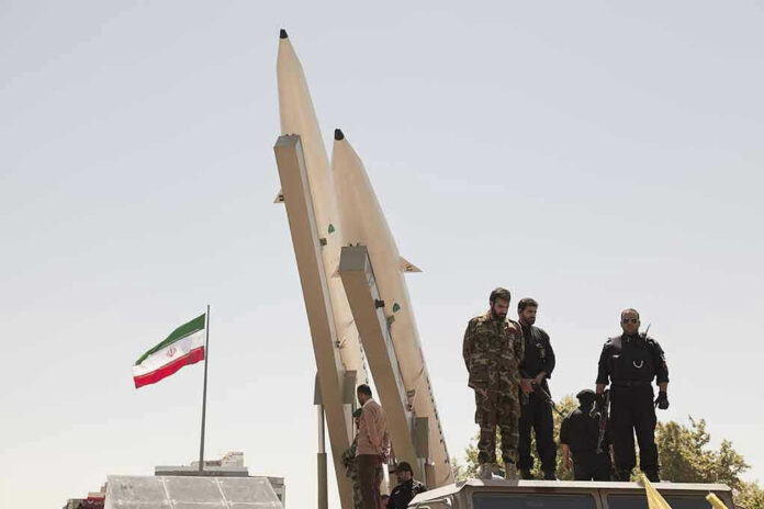Military personnel beside missiles and Iranian flag