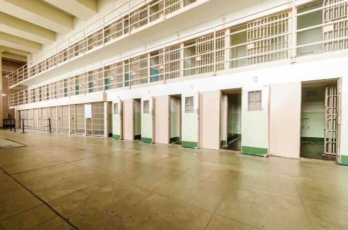 Interior view of a prison cell block with empty cells and security bars