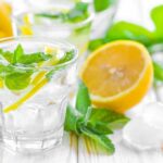 A refreshing drink with lemon slices and mint leaves in a clear glass