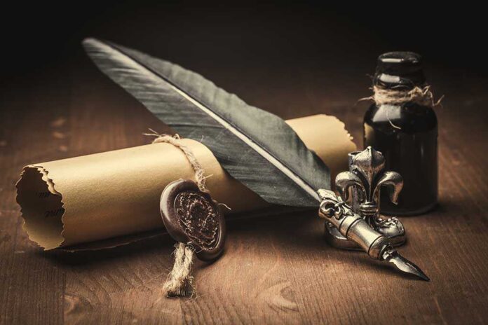 A quill pen, ink bottle, and sealed letter on a wooden surface