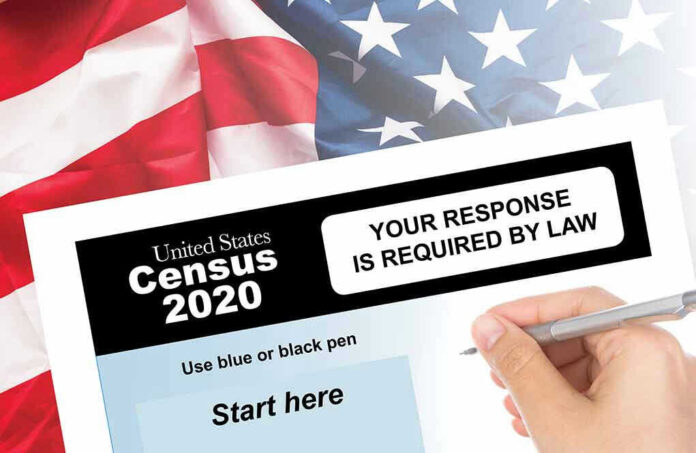 Hand filling out the U.S. Census 2020 form.