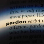 The word pardon highlighted in a dictionary.