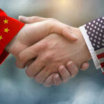 Chinese and American flag sleeves shaking hands.