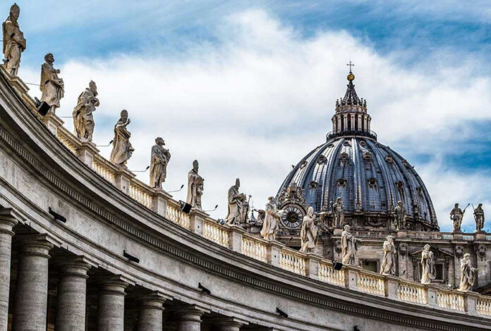 St. Peters Basilica dome with statues and clouds.