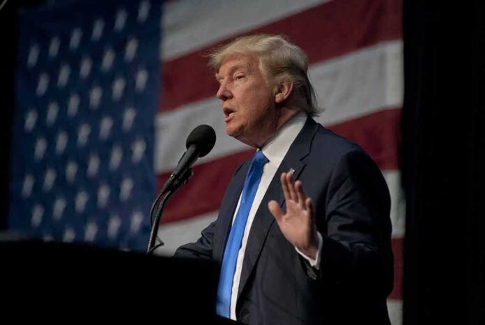 shutterstock_787487767.jpg A man in a suit speaking at a podium with an American flag in the background