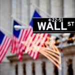 Wall Street sign with American flags in the background