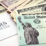 $2,000 Tariff Checks – Will Congress Approve? A tax refund check from the IRS alongside various denominations of cash