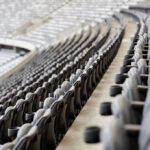 Empty rows of gray seats in a stadium.