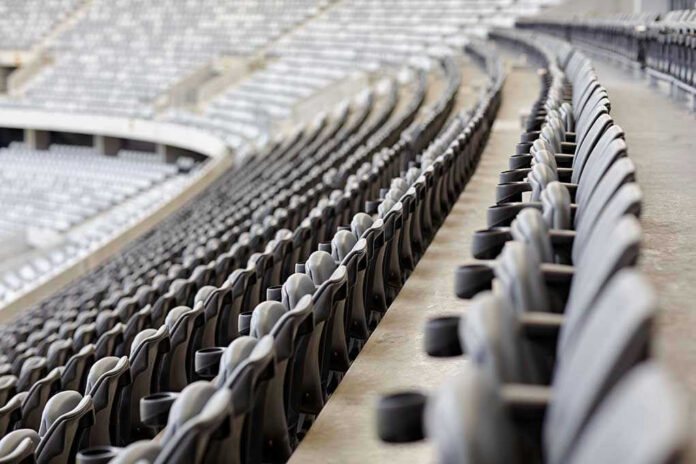 Empty rows of gray seats in a stadium.