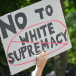 Sign saying No to white supremacy with red circle.