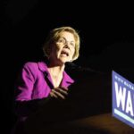A female politician delivering a speech at a podium with a campaign sign