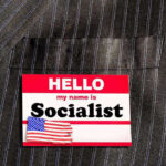 Hello my name is Socialist name tag on suit.