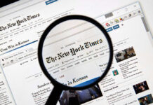 Magnifying glass over The New York Times website.