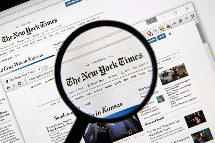 386787592 Magnifying glass over The New York Times website.