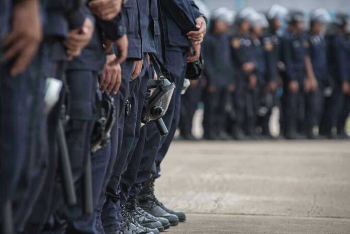 Line of police officers in uniform in formation.